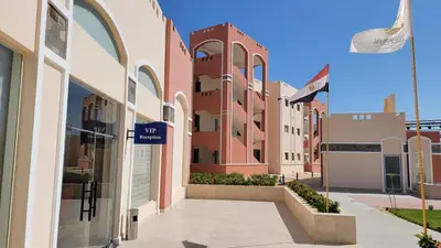 a street with buildings and a sign that reads shop at Oyster Bay Beach Resort - Luxury Serviced Condo in Marsa Alam City