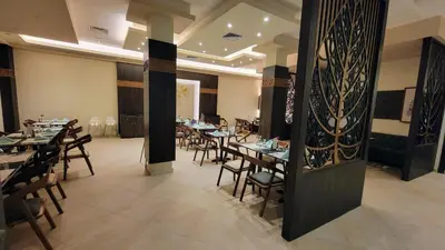 a restaurant with tables and chairs in a room at Oyster Bay Beach Resort - Luxury Serviced Condo in Marsa Alam City