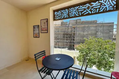 a table and chairs in a room with a window at Rugged & Relaxed 1 BDR Mangroovy Free Pool & Beach Access in Hurghada