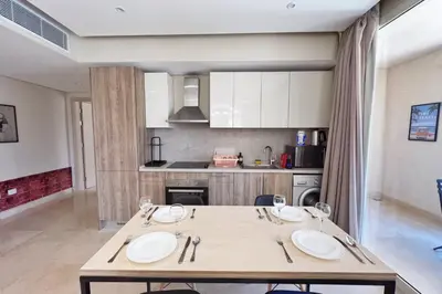 a kitchen with a wooden table with plates on it at Rugged & Relaxed 1 BDR Mangroovy Free Pool & Beach Access in Hurghada
