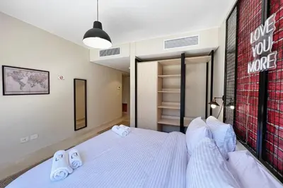 a bedroom with a bed and a brick wall at Rugged & Relaxed 1 BDR Mangroovy Free Pool & Beach Access in Hurghada