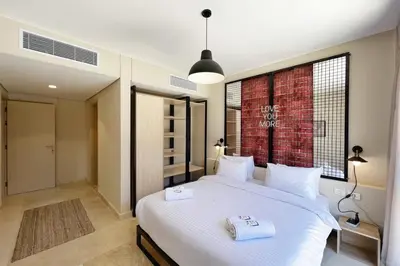 a bedroom with a large white bed with two towels on it at Rugged & Relaxed 1 BDR Mangroovy Free Pool & Beach Access in Hurghada