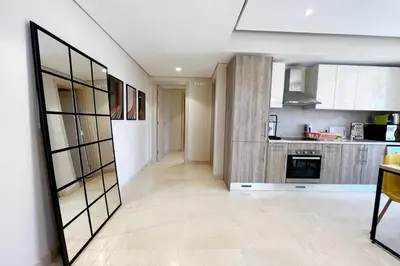 a kitchen with white cabinets and a large mirror at Enticing & Earthy 1 BDR Mangroovy Free Pool & Beach Access in Hurghada