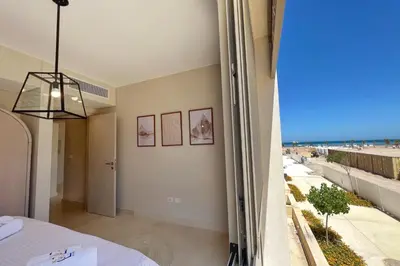a bedroom with a view of the beach at Perky 1 BDR Mangroovy Free Pool & Beach Access in Hurghada