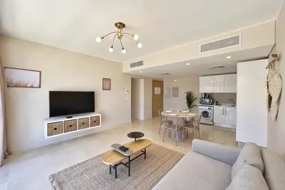 a living room with a couch and a tv and a table at Perky 1 BDR Mangroovy Free Pool & Beach Access in Hurghada