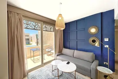 a living room with a couch and a table at Modern & Mellow 1 BDR Mangroovy Free Beach & Pool Access in Hurghada