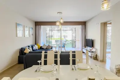 a living room with a table and a couch at Roomy & Relaxed 1BDR Mangroovy Free Beach & Pool in Hurghada