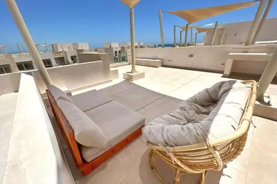 a bed and a chair on top of a roof at Seascape 1 BDR Mangroovy Pool & Sea View in Hurghada