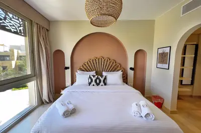 a bedroom with a large bed with slippers on it at Spectacular & Soaring 2 BDR w Private Rooftop Jacuzzi & Beach Access in Hurghada