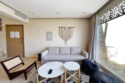 a living room with a couch and a table at Spectacular & Soaring 2 BDR w Private Rooftop Jacuzzi & Beach Access in Hurghada