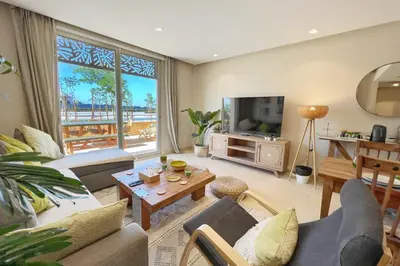 a living room with a couch and a tv at Sparky & Summery 2 BDR Mangroovy Free Beach & Pool Access in Hurghada
