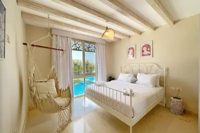 a bedroom with a swinging bed and a window at Radiant & Ravishing 2 BDR Mangroovy Free Beach & Pool Access in Hurghada