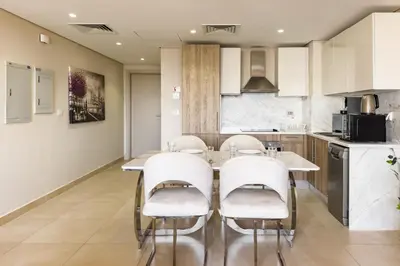 a kitchen with a table and chairs in a room at Charming 2BDR w Sea & Pool View Free Beach & Pool Access in Hurghada