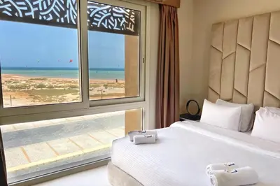 a bedroom with a bed and a view of the beach at Charming 2BDR w Sea & Pool View Free Beach & Pool Access in Hurghada
