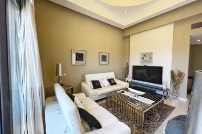 a living room with a white couch and a tv at Meditative & Blissful 2 BDR Villa Ancient Sands Private Pool in Hurghada