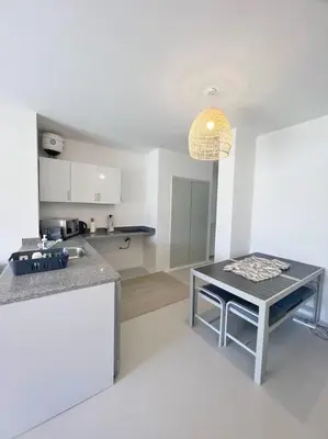 a kitchen with a table and a counter top at Lagoonfront Easy 1BDR Swan Lake El Gouna in Hurghada
