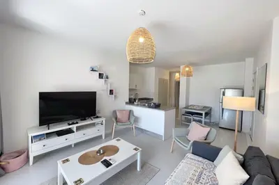 a living room with a couch and a tv at Lagoonfront Easy 1BDR Swan Lake El Gouna in Hurghada