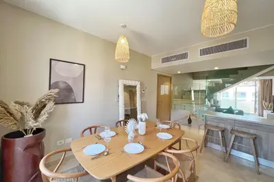 a dining room with a wooden table and chairs at Dazzling 2 BDR w Rooftop Mangroovy Free Pool & Beach Access in Hurghada
