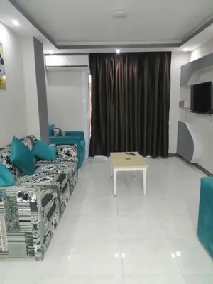 a room with a bed and a table in it at B in Hurghada