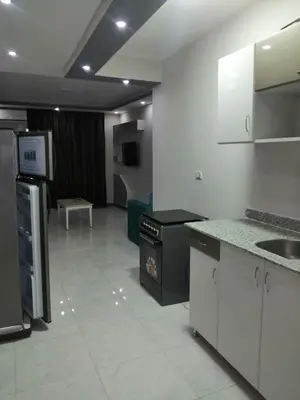 a kitchen with white cabinets and a black counter top at B in Hurghada