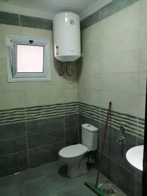 a bathroom with a toilet and a sink and a window at B in Hurghada
