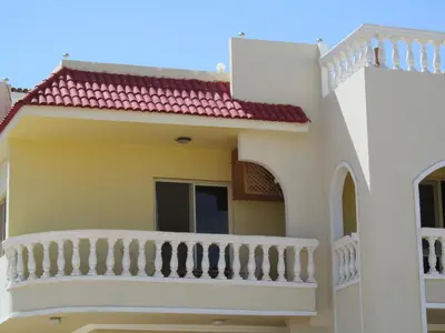a house with a balcony and a staircase at A Beautiful, Family-owned Penthouse Apartment, Overlooking the Red Sea Hurghada in Hurghada