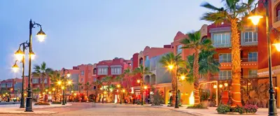 a city street with palm trees and buildings at night at A Beautiful, Family-owned Penthouse Apartment, Overlooking the Red Sea Hurghada in Hurghada