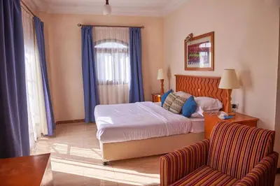 a hotel room with a bed and a couch at Sweet Rooms in Luxor