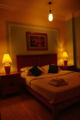 a bedroom with a large bed with two lamps at Sweet Rooms in Luxor