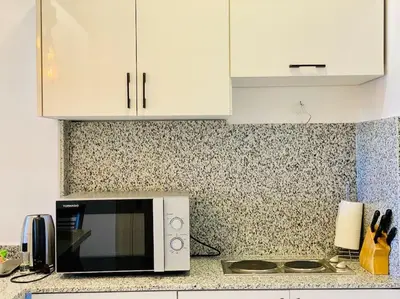 a kitchen counter with a microwave and white cabinets at Brand New 1-BR Apt @West Golf- El Gouna W/ a View! in Hurghada