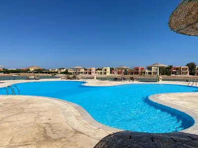 a large swimming pool with blue water at Brand New 1-BR Apt @West Golf- El Gouna W/ a View! in Hurghada
