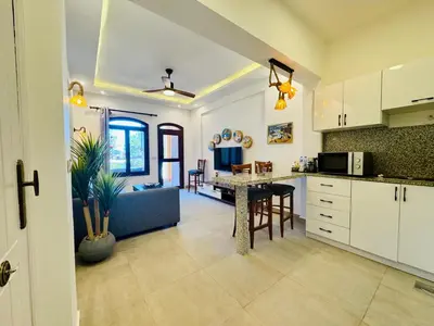 a kitchen and living room with a couch and a table at Brand New 1-BR Apt @West Golf- El Gouna W/ a View! in Hurghada