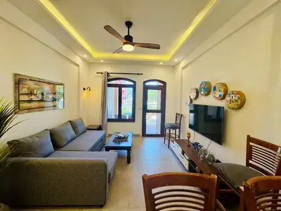 a living room with a couch and a flat screen tv at Brand New 1-BR Apt @West Golf- El Gouna W/ a View! in Hurghada