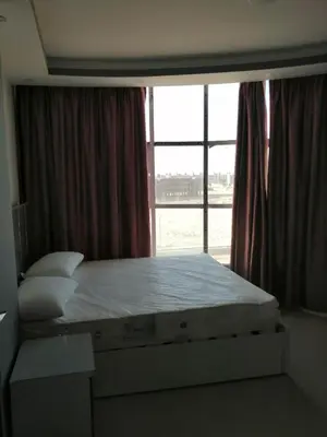 a bed in a room with a large window at 403 A in Hurghada