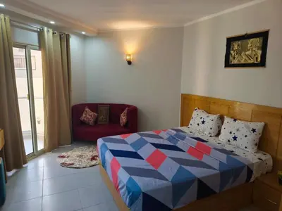 a bedroom with a bed and a red chair at Scandic Resort Apartments in Hurghada