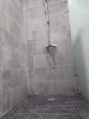 a shower in a bathroom with a tiled wall at Scandic Resort Apartments in Hurghada