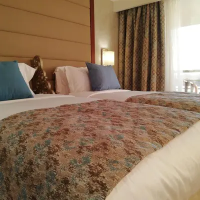 a hotel room with two beds and a window at Nile Cruise 3 nights From Aswan to Luxor Every Friday, Monday and Wednesday with tours in Jazīrat al ‘Awwāmīyah