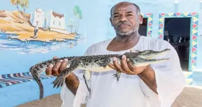 a man holding a fish in his hands at Kayan Guest House in Aswan