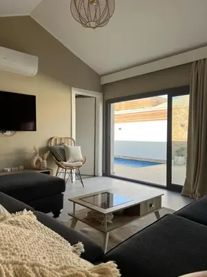 a living room with a couch and a glass coffee table at 2 Bedroom villa with private heated pool in Gouna in Hurghada