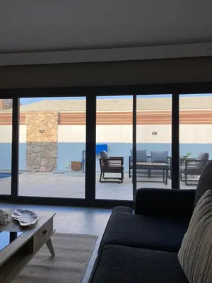 a living room with a couch and a view of a patio at 2 Bedroom villa with private heated pool in Gouna in Hurghada