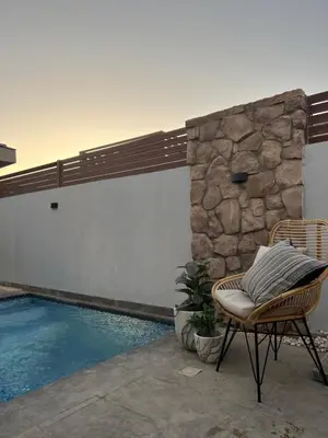 a chair sitting next to a swimming pool at 2 Bedroom villa with private heated pool in Gouna in Hurghada