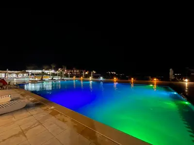 a swimming pool at night with blue water at Scandic Rezort in Hurghada