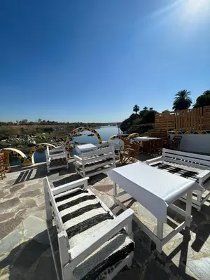 a white table and benches on top of a roof at Torya Nubian House in Aswan