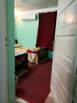 a room with a door and a room with two beds at Rose house in Aswan