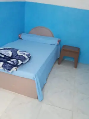a bed in a room with a blue wall at Rose house in Aswan
