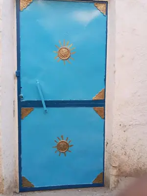a blue door with two suns on it at Rose house in Aswan