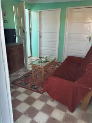 a living room with a red chair and a table at Rose house in Aswan