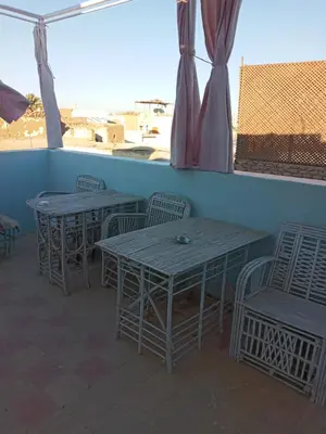 two tables and chairs sitting on a patio at Rose house in Aswan