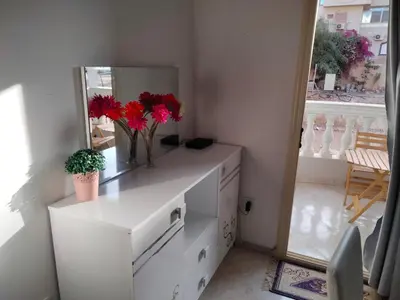 a white dresser with a mirror and red flowers on it at Hurghada Red Sea in Hurghada