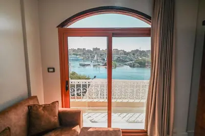 a living room with a large glass door to a balcony at Kana Kato in Aswan